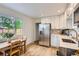 Eat-in kitchen area features bright window and stainless-steel refrigerator at 14317 Olmsted Dr, Denver, CO 80239