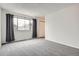 Bright bedroom featuring neutral carpet, a large window, and a closet at 12148 E Kepner Pl, Aurora, CO 80012