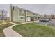 Green townhouse with lawn, sidewalk, and parking lot creating a comfortable neighborhood at 12148 E Kepner Pl, Aurora, CO 80012