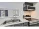 Modern kitchen equipped with stainless steel appliances and a double basin sink at 12148 E Kepner Pl, Aurora, CO 80012