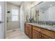 Well-lit bathroom with a double sink vanity, decorative mirror, and tiled floors at 16671 E Prairie Goat Ave, Parker, CO 80134