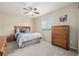 A comfortable bedroom offers a window view, wood furniture, and a ceiling fan at 16671 E Prairie Goat Ave, Parker, CO 80134