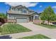 Inviting two-story home featuring a well-manicured lawn, mature landscaping, and a two-car garage at 16671 E Prairie Goat Ave, Parker, CO 80134