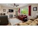 Comfortable living room with a fireplace, ceiling fan, hardwood floors, and large window at 16671 E Prairie Goat Ave, Parker, CO 80134