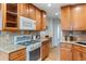 Well-equipped kitchen featuring natural wood cabinets, granite counters, and a modern gas range at 16 N Pennsylvania St, Denver, CO 80203