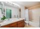 Bright bathroom features a double vanity and a shower-tub combo with tile surround at 22765 E Ottawa Pl, Aurora, CO 80016
