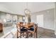 Open-concept dining area adjacent to the living room with a wooden table and modern lighting at 22765 E Ottawa Pl, Aurora, CO 80016