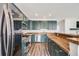 Spacious kitchen with stainless steel appliances, dark green cabinets, and breakfast bar at 22765 E Ottawa Pl, Aurora, CO 80016