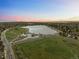Stunning aerial view of a community lake and green space at sunset, showcasing the surrounding neighborhood at 6402 W 81St Ave, Arvada, CO 80003