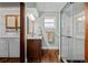Modern bathroom featuring wood floors, vanity with sink, and a stylish glass-enclosed shower, adjacent to washer and dryer at 6402 W 81St Ave, Arvada, CO 80003
