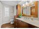 Well-lit bathroom featuring vanity with sink, a decorative plant and a toilet at 6402 W 81St Ave, Arvada, CO 80003