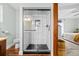 Walk in shower has white tile and black accents that highlight the updated bathroom at 6402 W 81St Ave, Arvada, CO 80003