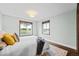 Cozy bedroom featuring hardwood floors, two windows, area rug and a comfortable bed at 6402 W 81St Ave, Arvada, CO 80003
