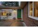 Cozy entrance with brick exterior, a vibrant green door, and an inviting outdoor seating area at 6402 W 81St Ave, Arvada, CO 80003