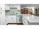 Bright kitchen features white cabinets, stainless appliances, stylish backsplash and quartz counters at 6402 W 81St Ave, Arvada, CO 80003