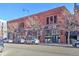 A sunny, street-level view of the commercial building's brick facade, featuring large windows and street parking at 1732 Wazee St # 201, Denver, CO 80202