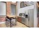 Modern kitchen with stainless steel appliances, wood cabinets, and a counter height dining table at 1732 Wazee St # 201, Denver, CO 80202