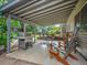 Covered back patio features a grill, seating area, outdoor lighting and firewood for enjoying the outdoors at 4720 W Stanford Ave, Denver, CO 80236
