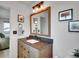 Bathroom with a wooden vanity, stone countertop, modern lighting and framed art at 4720 W Stanford Ave, Denver, CO 80236