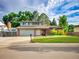Charming two-story home with a lush green lawn, brick accents, and an attached two-car garage at 4720 W Stanford Ave, Denver, CO 80236