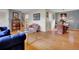 Open concept living room with a blue sofa, coffee table, armchair, dining table, and hardwood floors at 4720 W Stanford Ave, Denver, CO 80236