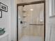 Modern bathroom shower with glass enclosure, built-in shelves, and updated fixtures at 4720 W Stanford Ave, Denver, CO 80236