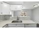 Modern kitchen featuring quartz countertops, a stainless steel sink, and white cabinetry at 2927 W 81St Ave # B, Westminster, CO 80031