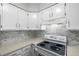 Bright kitchen featuring white cabinets, quartz countertops, gray backsplash, and modern appliances at 2927 W 81St Ave # B, Westminster, CO 80031