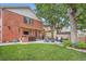Expansive backyard with brick exterior, built-in grill, outdoor seating, and a lush green lawn at 2436 W Argyle Pl, Denver, CO 80211