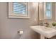 Elegant powder room featuring a pedestal sink, decorative wallpaper, and a stylish window at 2436 W Argyle Pl, Denver, CO 80211