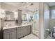 A stylish bathroom features a double vanity, modern fixtures and a frameless glass shower at 2436 W Argyle Pl, Denver, CO 80211