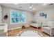 A charming Bedroom features hardwood floors, bright windows and a cute letter rug at 2436 W Argyle Pl, Denver, CO 80211