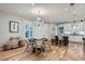 Open-concept dining area adjacent to a modern kitchen, featuring a stylish chandelier and seating at 2436 W Argyle Pl, Denver, CO 80211