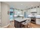 Bright kitchen with white cabinets, a large island, stainless steel appliances, and access to outdoor space at 2436 W Argyle Pl, Denver, CO 80211