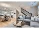 Open-concept living space with modern decor, hardwood floors, a staircase, and a view into the kitchen at 2436 W Argyle Pl, Denver, CO 80211
