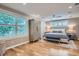 A spacious bedroom features light hardwood floors, large windows, and a decorative area rug at 2436 W Argyle Pl, Denver, CO 80211