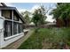 Landscaped backyard featuring green lawn, tall fence, and bright white exterior with black-trimmed windows at 8249 Zephyr St, Arvada, CO 80005