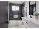 Stylish bathroom with sleek black tiles, white vanity, and modern fixtures for a spa-like experience at 8249 Zephyr St, Arvada, CO 80005