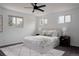 Bright bedroom featuring a ceiling fan, neutral decor, and three windows for natural light at 8249 Zephyr St, Arvada, CO 80005