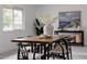 Dining room with a large table, black chairs, and a modern beach-themed painting at 8249 Zephyr St, Arvada, CO 80005