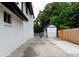 Long driveway extends to a backyard storage shed, complimented by lush surrounding greenery and fence at 8249 Zephyr St, Arvada, CO 80005