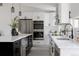 Modern kitchen featuring white cabinets, black hardware, stainless steel appliances, and a contrasting black island at 8249 Zephyr St, Arvada, CO 80005