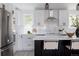 Bright kitchen features white cabinets, a large stainless steel refrigerator, and a center island with seating at 8249 Zephyr St, Arvada, CO 80005