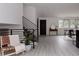Open-concept living area featuring a staircase, a decorative table with a mirror, and a view into the dining area at 8249 Zephyr St, Arvada, CO 80005