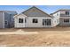 Backyard view features house with sliding doors, bay windows and dirt yard at 9112 Telluride Ct, Commerce City, CO 80022
