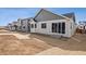 Backyard features the rear of the home with a bay window and sliding glass doors at 9112 Telluride Ct, Commerce City, CO 80022