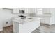 Bright kitchen showcasing an island with stainless steel appliances, white cabinets, and quartz countertops at 9112 Telluride Ct, Commerce City, CO 80022