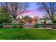 Large backyard featuring mature trees, tiered landscaping, and a covered patio with seating at 7900 Crest Dr, Lakewood, CO 80214