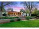 Charming backyard oasis featuring a lush lawn, stone patio, and outdoor dining area perfect for entertaining at 7900 Crest Dr, Lakewood, CO 80214