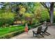 Lush backyard with a stone patio, mature trees, and cozy seating, creating a tranquil outdoor space at 7900 Crest Dr, Lakewood, CO 80214